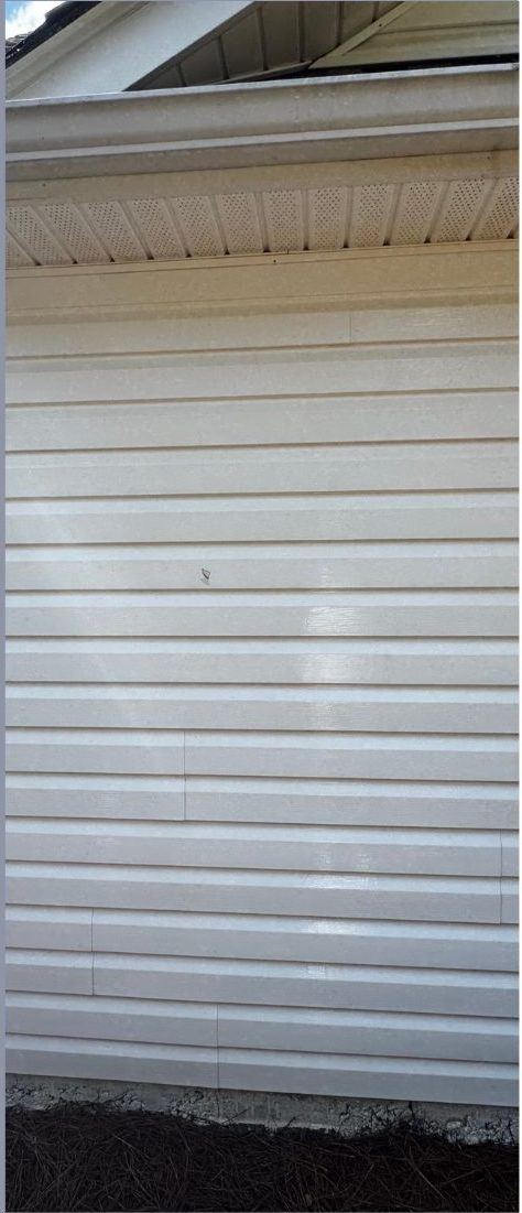 The same vinyl siding after a low-pressure soft wash, with the algae removed and the siding returned to clean white
